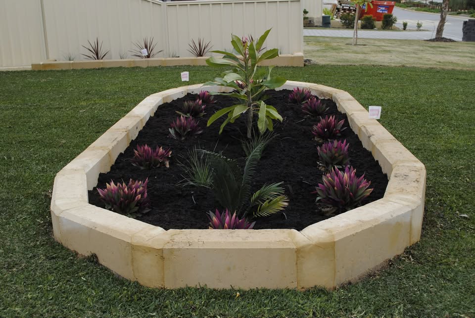 Lush finished garden bed with limestone edging by SOLE Tree & Landscaping Service